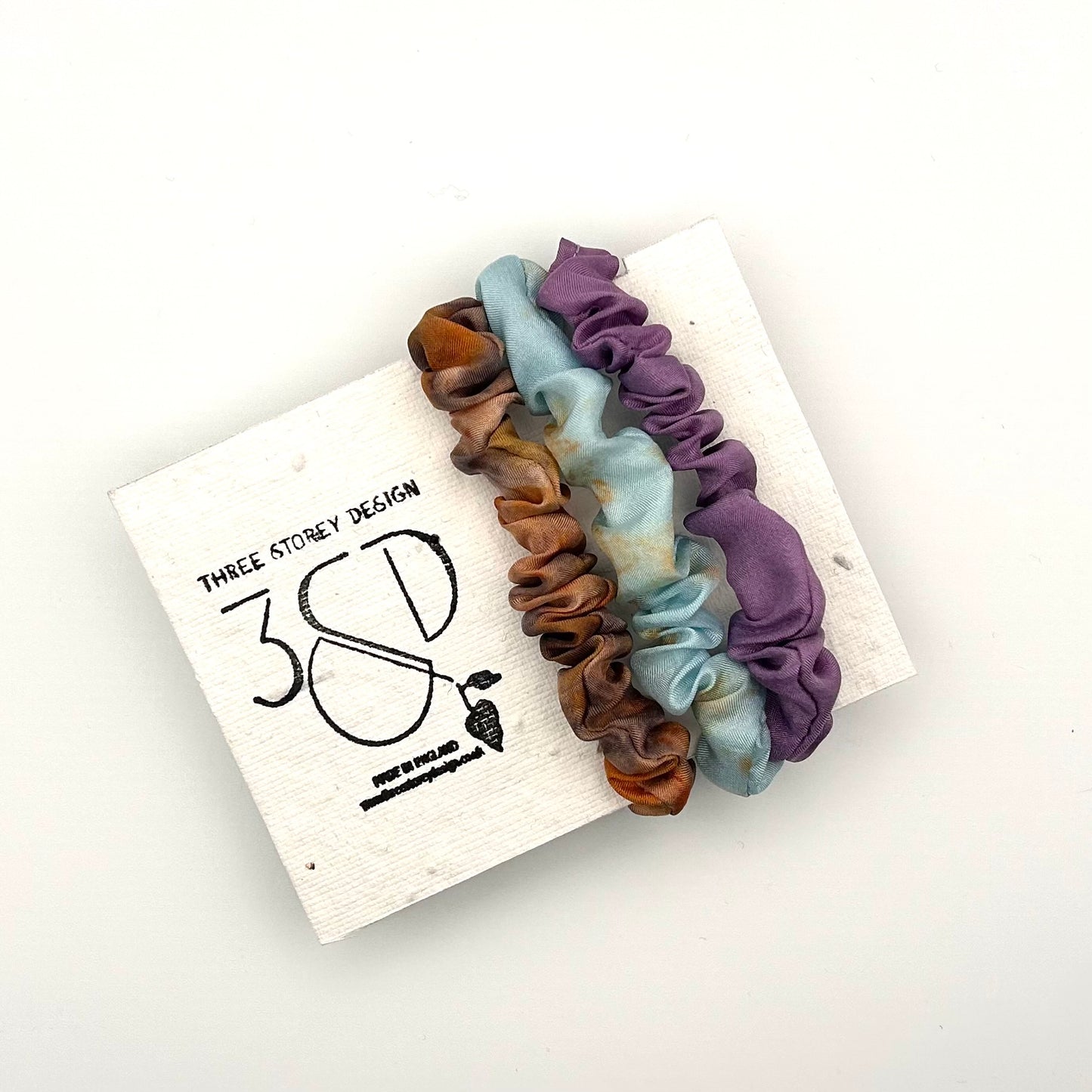 Camel , Blue and Purple naturally dyed 3 pack mini silk scrunchies presented on plantable branded packaging