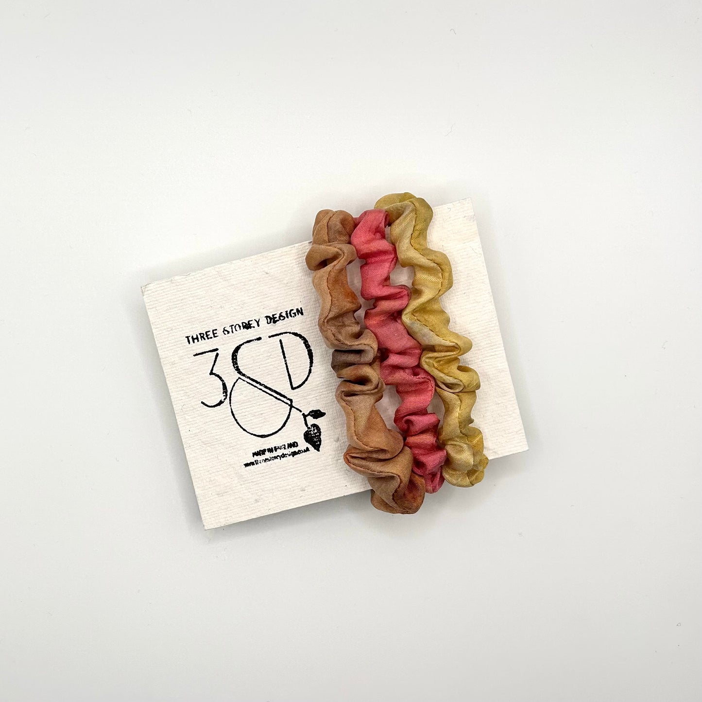 Camel , Pink and Yellow naturally dyed 3 pack mini silk scrunchies presented on plantable branded packaging