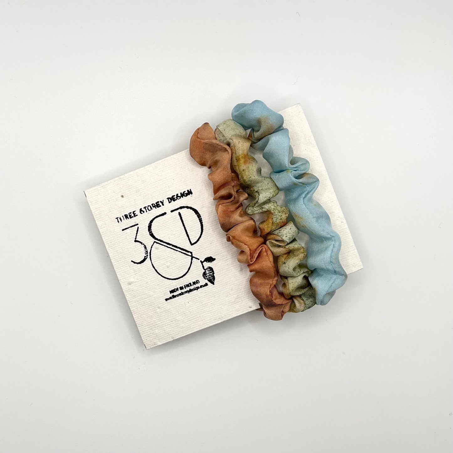Camel , green and blue naturally dyed 3 pack mini silk scrunchies presented on plantable branded packaging