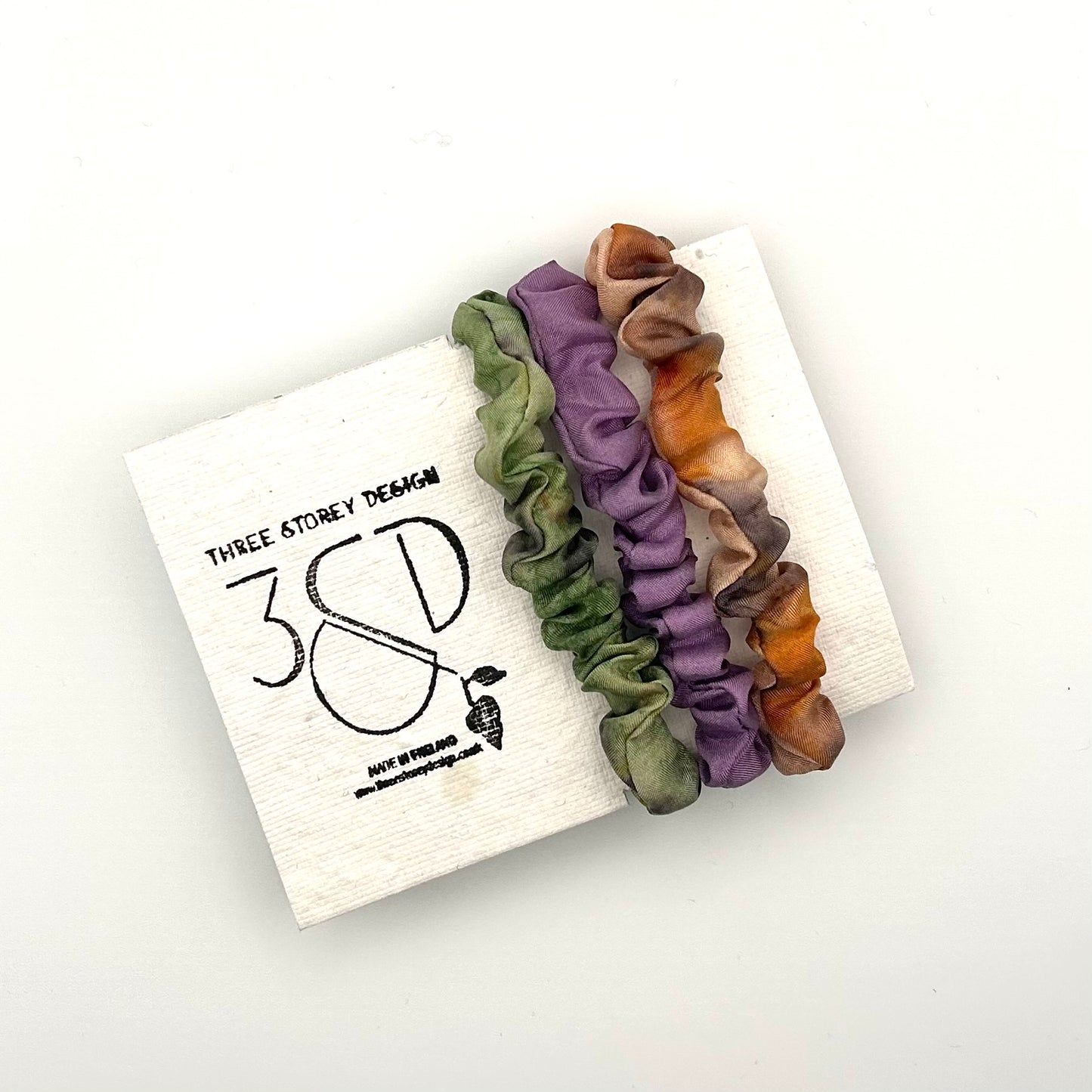 Green , Purple and Camel naturally dyed 3 pack mini silk scrunchies presented on plantable branded packaging