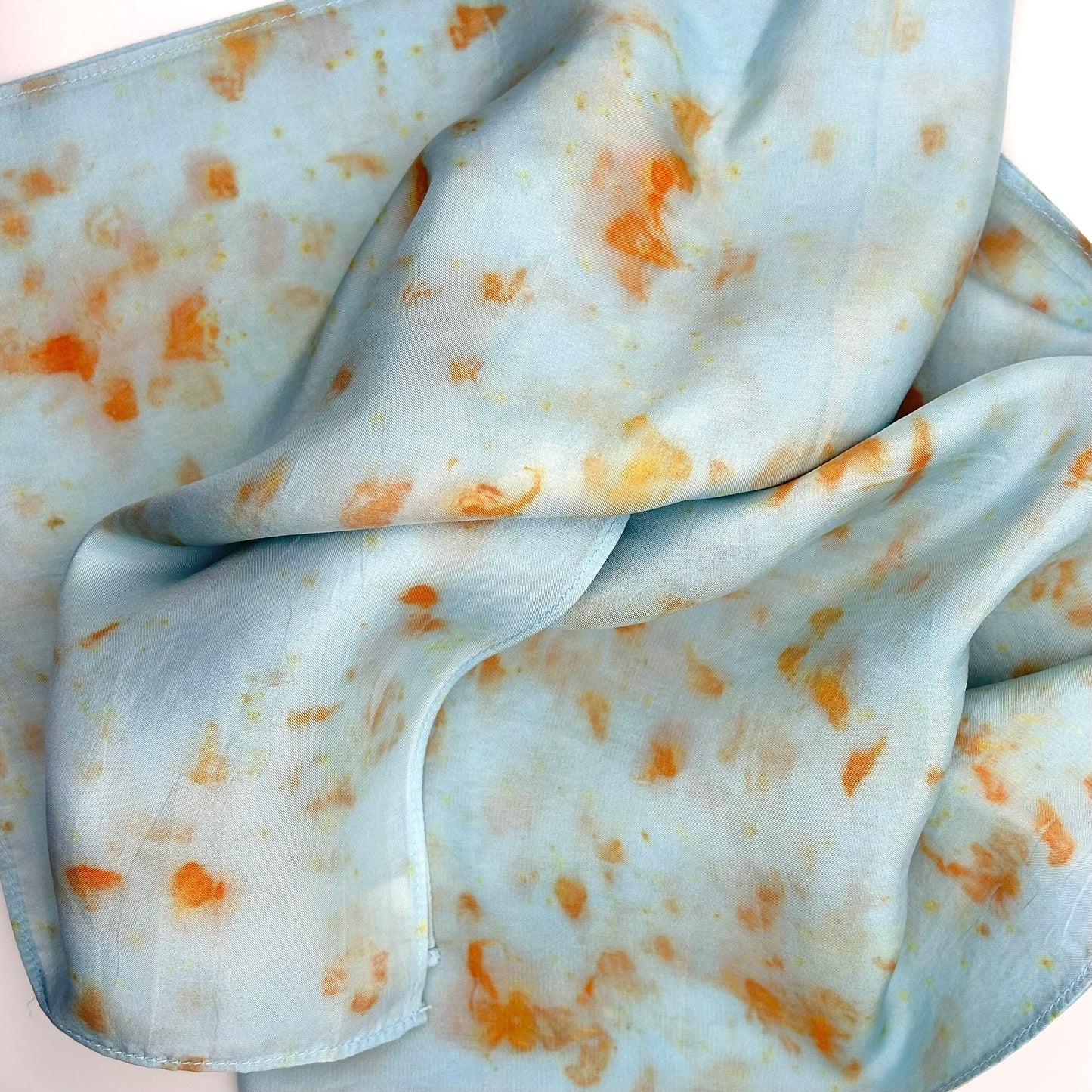 Pale indigo long silk scarf with orange cosmos naturally dyed print scrunched up