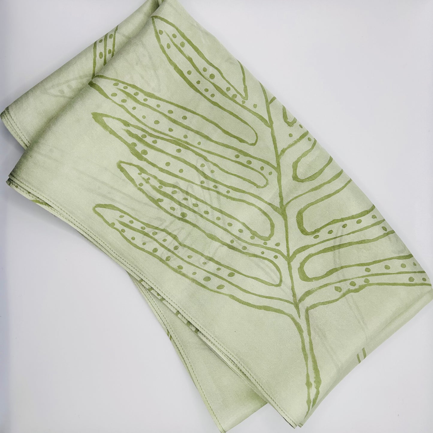 Pale green long silk scarf with naturally dyed hand-painted leaf print showing scarf folded
