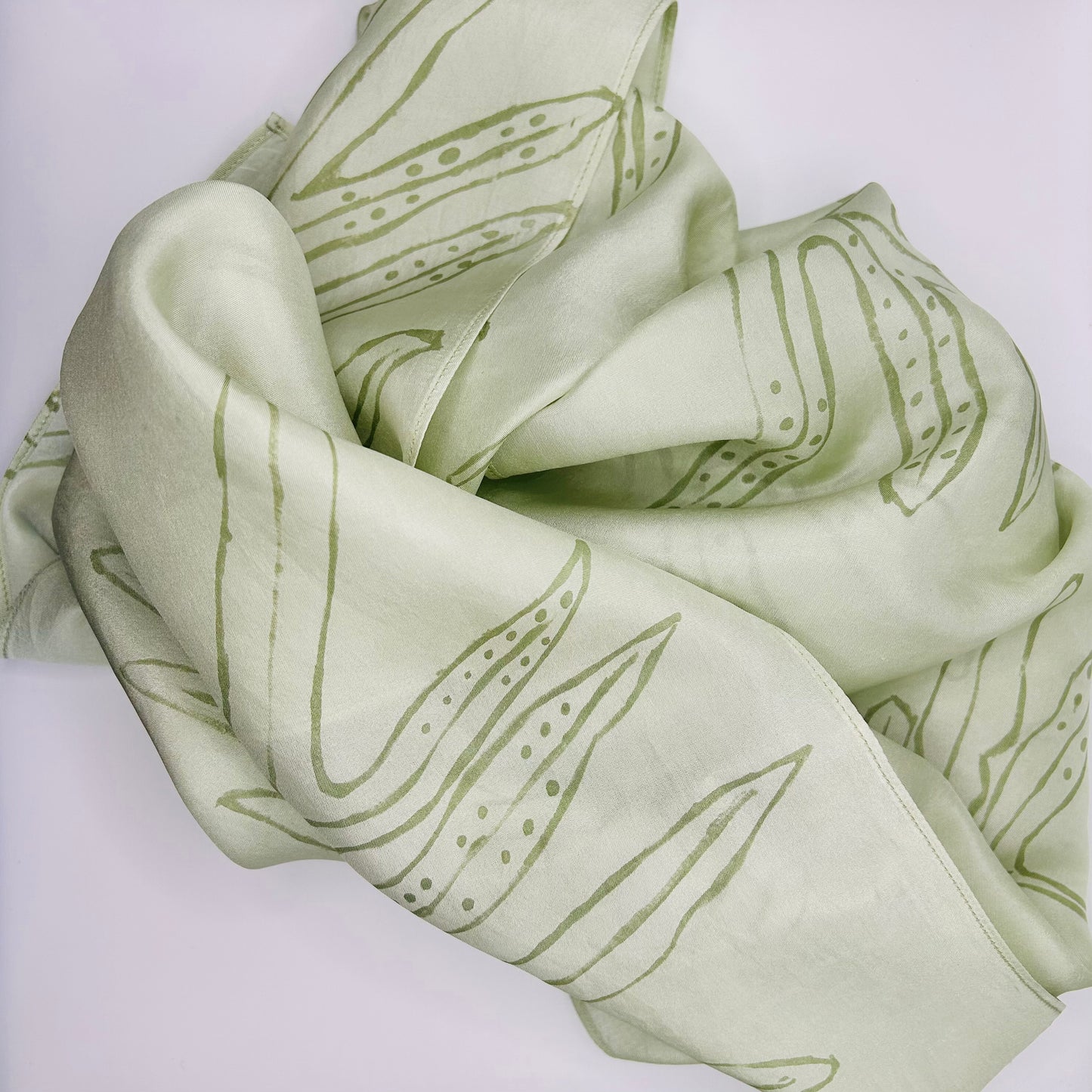 Pale green long silk scarf with naturally dyed hand-painted leaf print scrunched up