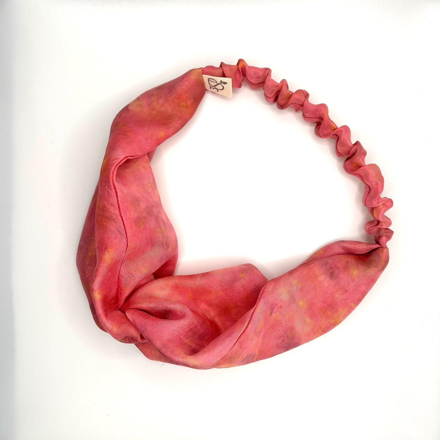 Pink floral silk turban headband with elastic to secure over head which has been naturally dyed with yellow chamomile flowers
