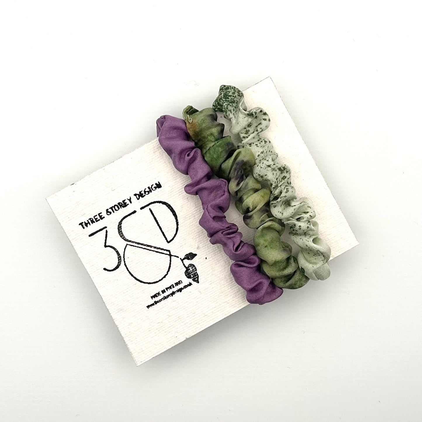 Purple , Green and Pale Green naturally dyed 3 pack mini silk scrunchies presented on plantable branded packaging