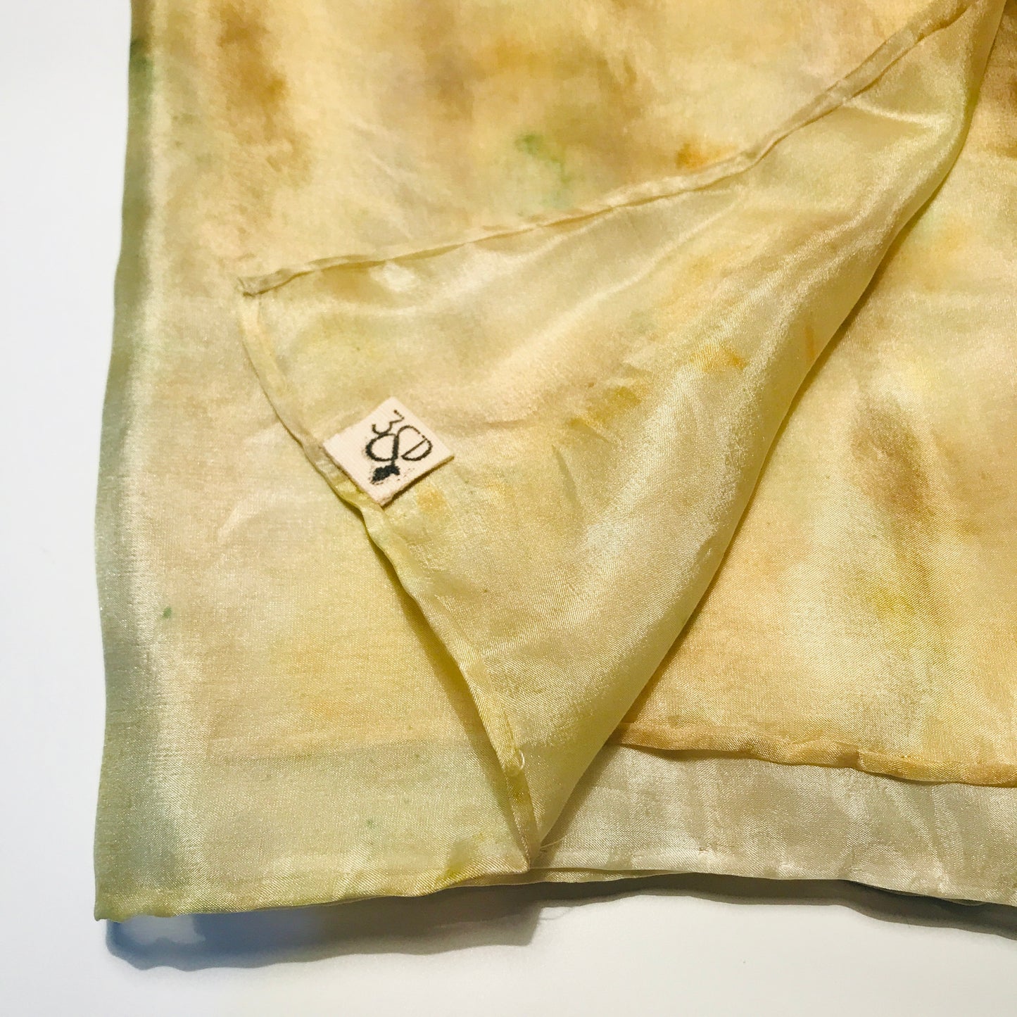 Yellow long silk scarf with naturally dyed marigold print folded into a square