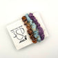 Camel , Blue and Purple naturally dyed 3 pack mini silk scrunchies presented on plantable branded packaging