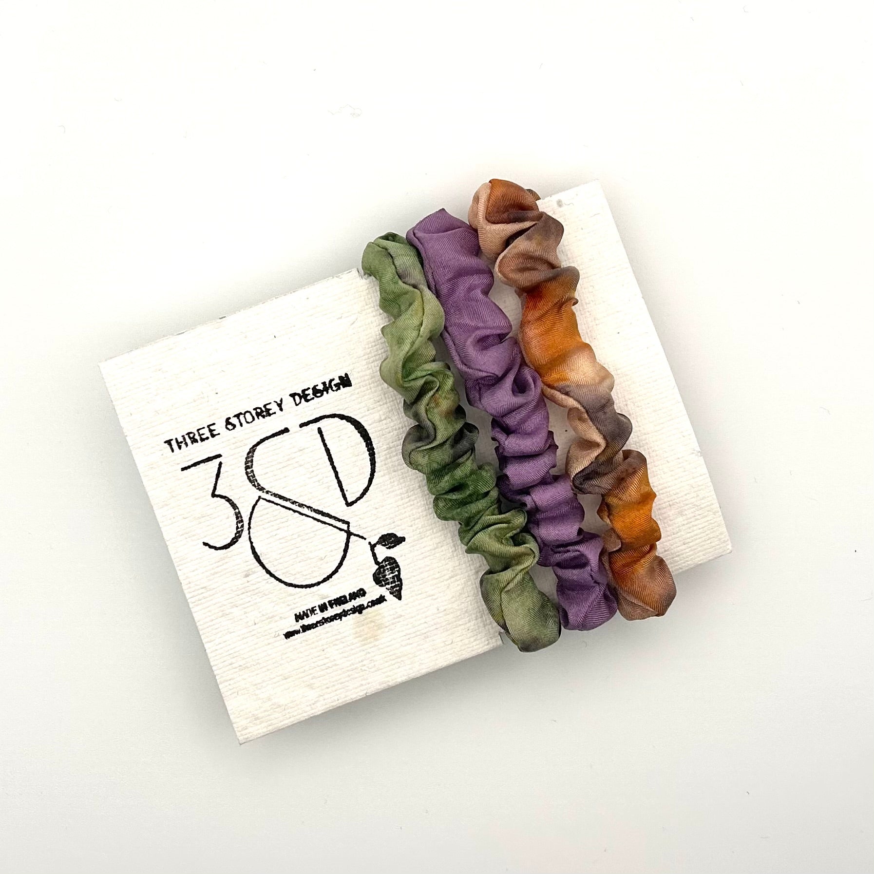 Green , Purple  and Camel naturally dyed 3 pack mini silk scrunchies presented on plantable branded packaging
