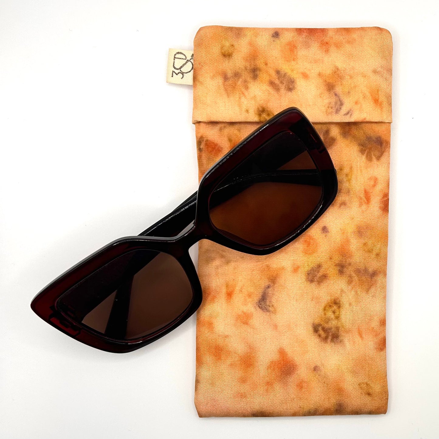 Pale Orange Glasses Case front naturally dyed silk, printed with Orange cosmos, coreopsis and extract dye , displayed with sunglasses
