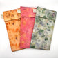 3 Naturallly dyed Silk Glasses Cases, displayed in a fan , pale orange, Pink Floral and Green Garden colours