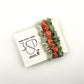 Pale green, Peach and Green naturally dyed 3 pack mini silk scrunchies presented on plantable branded packaging