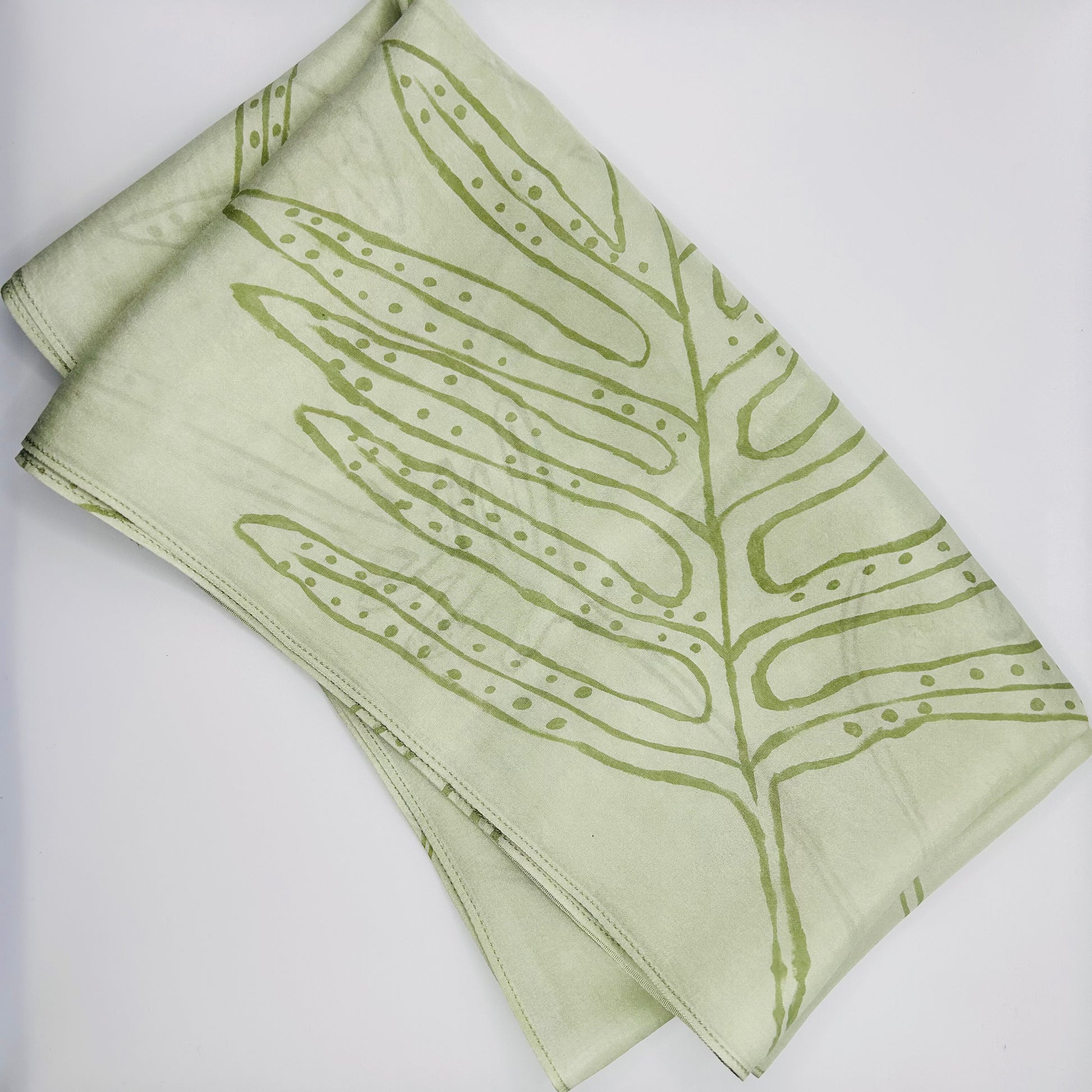 Pale green long silk scarf with naturally dyed hand-painted leaf print showing scarf folded