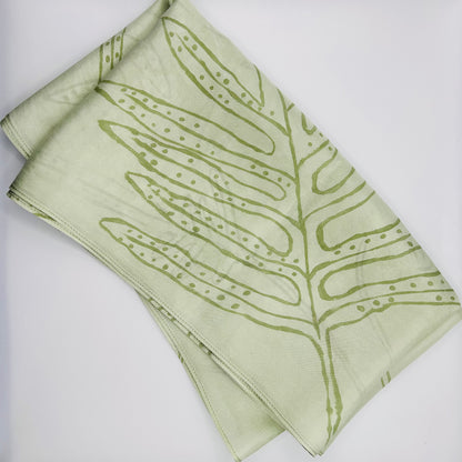 Pale green long silk scarf with naturally dyed hand-painted leaf print showing scarf folded