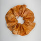 Pale orange silk scrunchie naturally dyed with orange cosmos, coreopsis and madder print