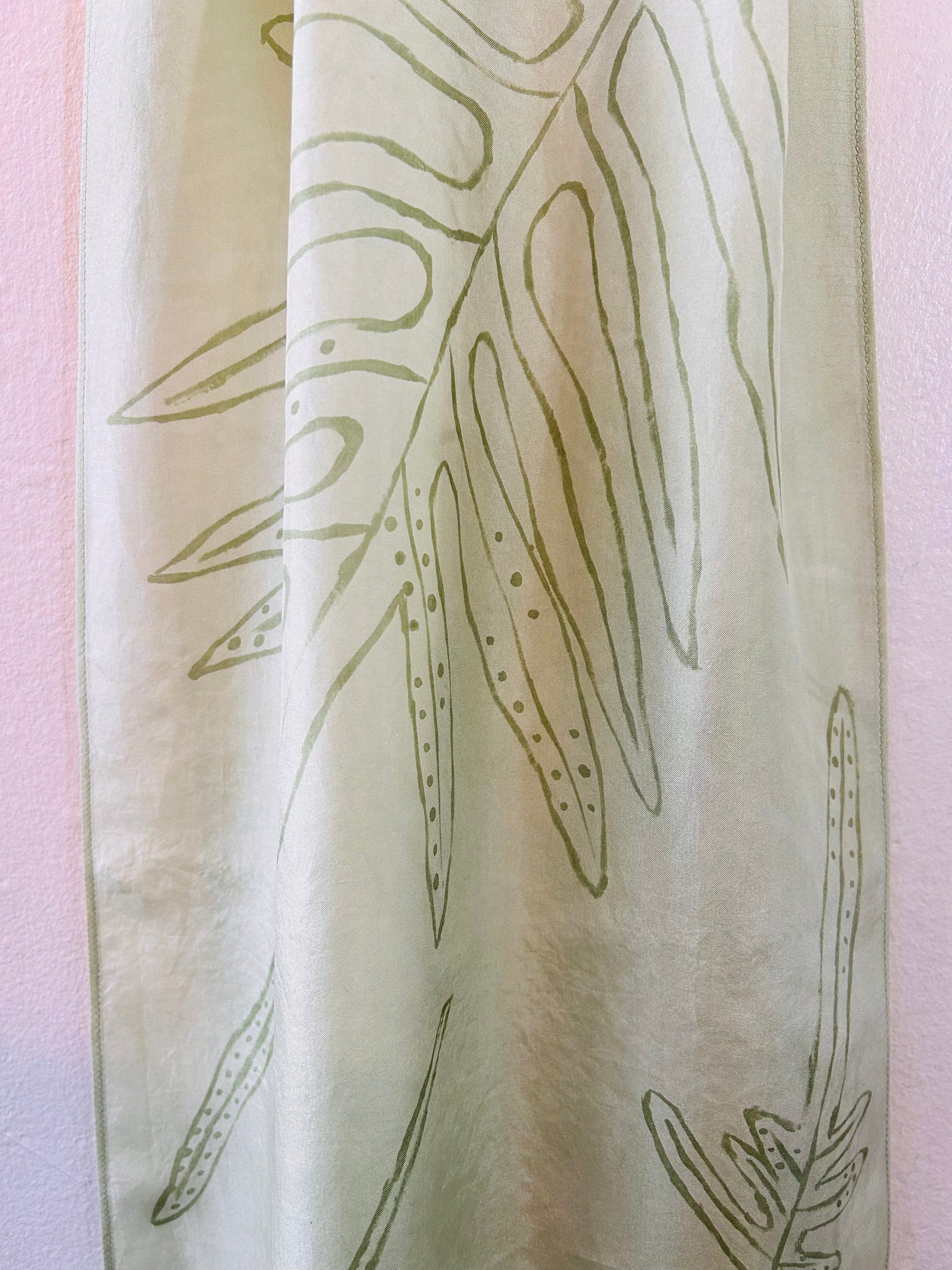 Pale green long silk scarf with naturally dyed hand-painted leaf print  showing close up of pattern 