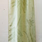 Pale green long silk scarf with naturally dyed hand-painted leaf print displayed on hanger showing half the length