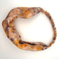 Peach silk turban headband with elastic to secure over head which has been naturally dyed with orange cosmos flowers and black beans