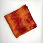 Red and orange flame naturally dyed  silk square scarf  folded into a square