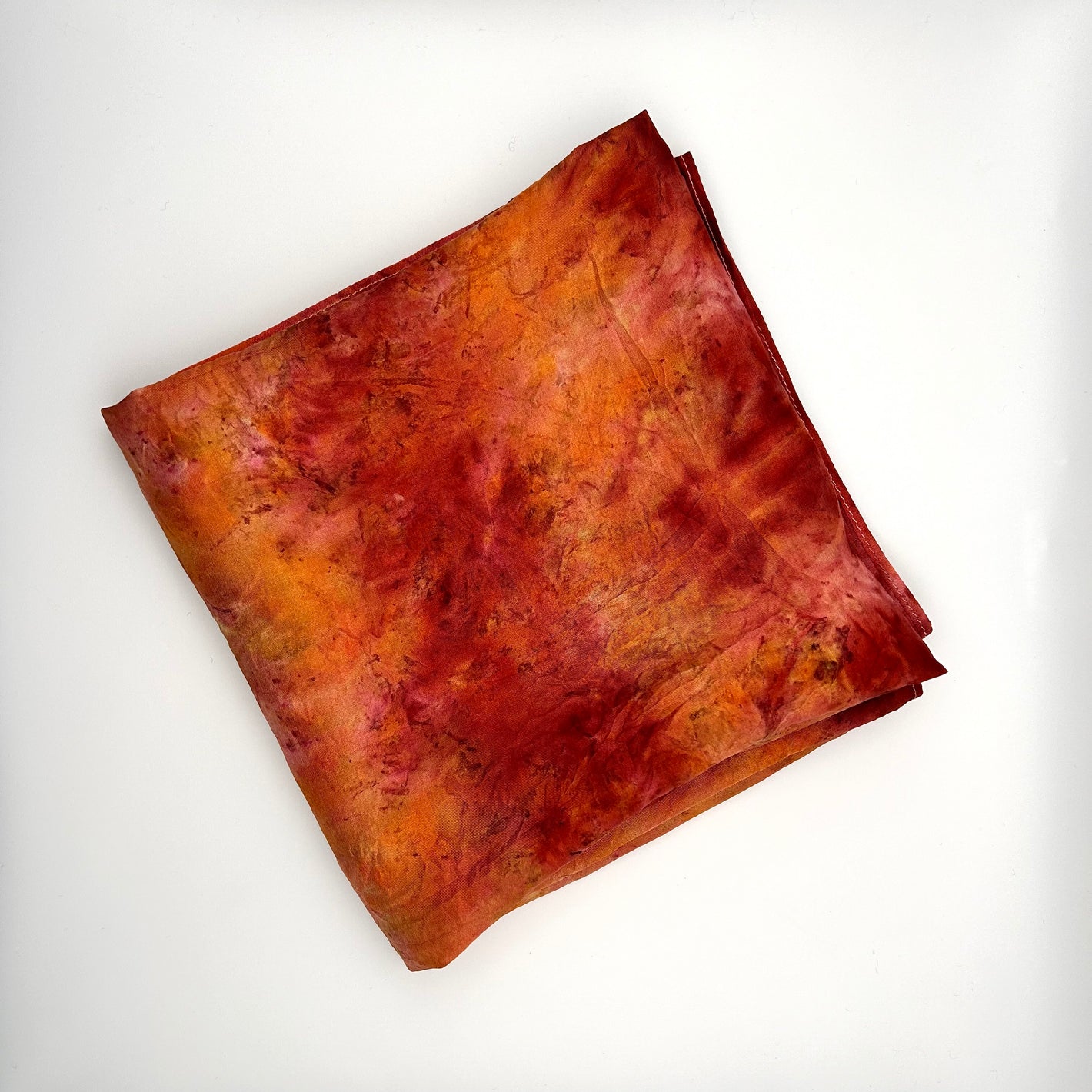 Red and orange flame naturally dyed  silk square scarf  folded into a square